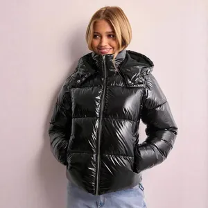 Detailed view of a stylish women's black glossy hooded puffer jacket for winter warmth