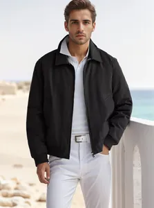 Caucasian male model wearing a black zip-up commuter jacket on a bright beach balcony