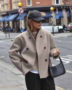 Stijlvolle wollen jas met dubbele rij knopen voor dames in beige voor een Britse look.