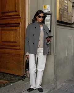 Elegante grijze wollen jas met dubbele rij knopen, gestyled in een chique urban street-outfit