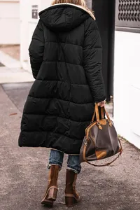 Back view of long black hooded puffer jacket worn with jeans and brown boots