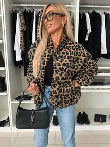 Eine stilvolle Frau in einer Retro-Leopardenjacke, die eine schicke schwarze Handtasche hält