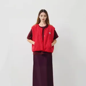 Gilet polaire rouge sans manches porté sur un haut sombre et une jupe par un mannequin