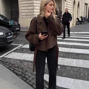 Femme à la mode portant une veste courte en laine marron avec ceinture dans la rue