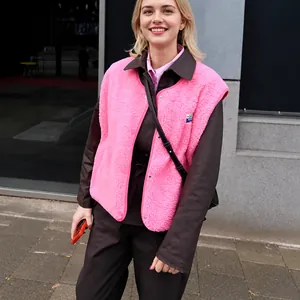 Détail en gros plan d'un gilet sans manches en polaire rose vif porté par un mannequin.