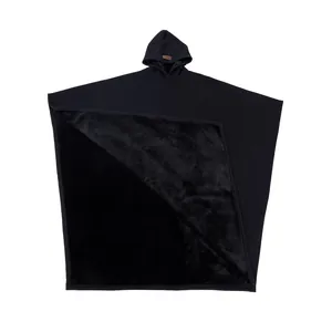Dettaglio del poncho con cappuccio oversize con fodera in pile nero spessa e morbida