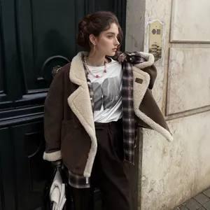 Model toont een losse vintage bruine lamswollen jas in stijlvolle buitenomgeving