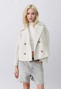 Dettaglio di un'elegante giacca corta in lana color crema con ampi revers moda