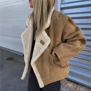 Detail van een oversized bruine suède jas met witte lamswollen voering voor winter