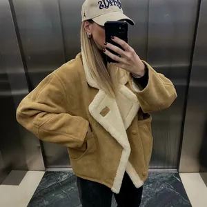 Detailweergave van een vintage damesjas van lamswol in camel met een crème voering.