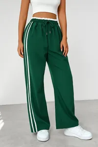 Detail view of women's high-waisted green sweatpants with white side stripes.