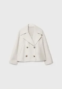Dettaglio del grande colletto a revers e bottoni marmorizzati su cappotto bianco