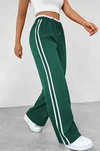 Detailed view of green high-waisted wide-leg track pants with double white side stripes.