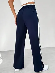 Back view of navy blue high-waisted sports pants with white side stripes and wide-leg cut