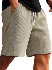 Close-up of men's beige waffle knit shorts with adjustable white drawstring