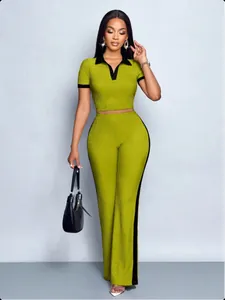Full body view of a woman wearing a green two-piece ribbed outfit with black contrast details.