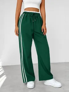 Stylish women's dark green wide-leg track pants featuring white side stripes and high waist
