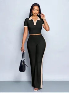 Full length view of a chic women's two-piece black set with contrast trim polo top and pants