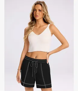 Modella indossa pantaloncini neri con coulisse, cuciture bianche e top bianco