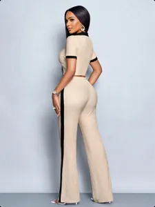 Side view of women's beige textured two-piece set with black trim and side stripe.