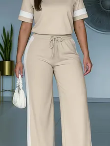 Vista dettagliata del completo beige due pezzi da donna con strisce bianche laterali