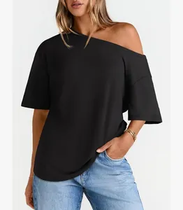 Dettaglio di una t-shirt nera con spalla scoperta in cotone a taglio ampio da donna