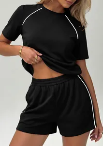 Dettaglio del set casual nero a due pezzi con strisce bianche su shorts e t-shirt