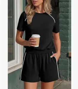 Dettaglio di un completo casual nero a due pezzi da donna con strisce profilate bianche