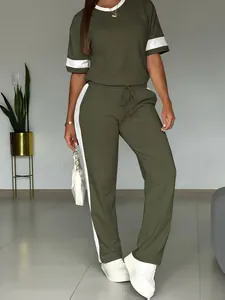 Dettaglio dell'abbigliamento casual verde oliva con strisce laterali bianche.