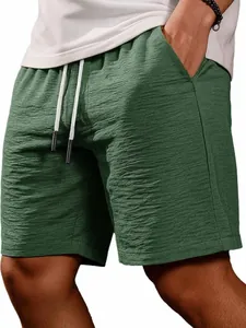 Detailed view of men's casual green shorts with textured fabric and white drawstring