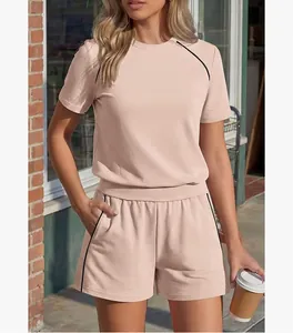 Completo due pezzi da donna rosa pesca con bordi a contrasto indossato da una modella.