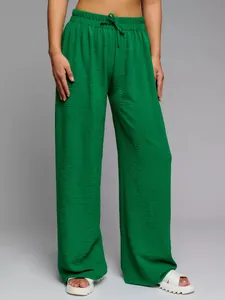 Detailed view of vibrant green high-waisted wide-leg pants featuring textured crepe fabric
