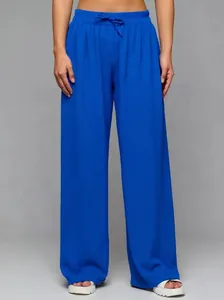 Detail of high-waisted royal blue wide-leg trousers with drawstring waist and flowing fit.