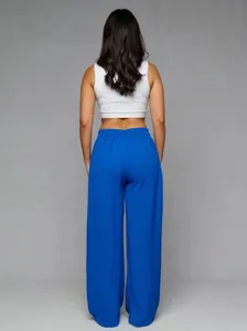 Back view of royal blue high-waisted wide-leg trousers featuring an elegant drape