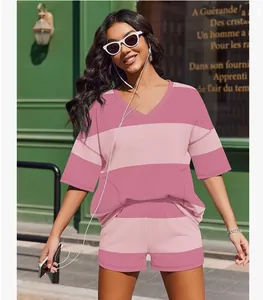 Woman wearing pink striped two-piece casual set with shorts and V-neck top outdoors