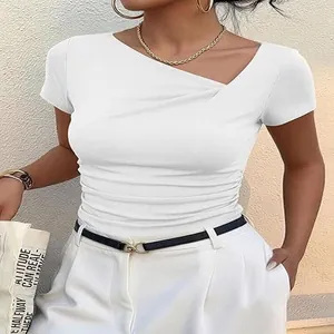 Détail de l'encolure asymétrique et des fronces sur un t-shirt blanc ajusté