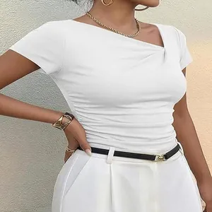 Détail d'un t-shirt blanc moulant avec encolure asymétrique et détails plissés