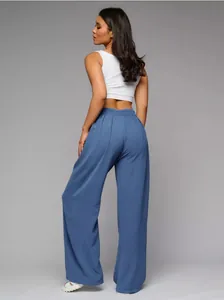 Back view showing the high-waist fit and elegant drape of blue wide-leg trousers
