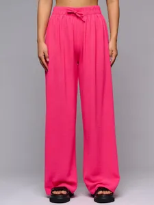 Vibrant pink high-waisted wide-leg trousers with elegant drape and comfortable elastic waist