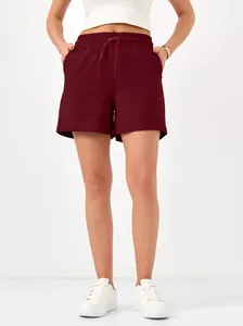 Detail view of burgundy drawstring casual shorts with elastic waist and pockets.