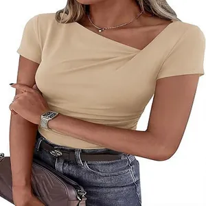 Détail d'un t-shirt beige pour femme à encolure asymétrique et plis, coupe ajustée