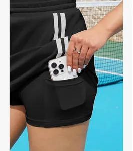 Detail van de functionele binnenzak van een zwarte tennis-skort met witte zijstrepen.