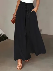 Full-length view of elegant black wide-leg trousers with elastic waist on model