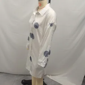 Side view of white long sleeve shirt dress with blue polka dot print on a mannequin