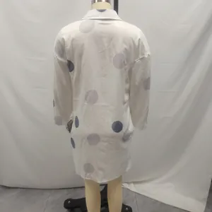 Back view of a white long-sleeve women's shirt dress with grey polka dot pattern