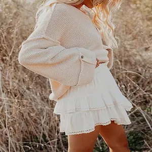 Detail view of white tiered ruffle mini skirt with lace hem in a bohemian outdoor style.