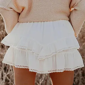 Close-up detail of a bohemian white tiered ruffled mini skirt with lace trim edges