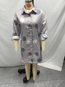 Detail of women's long sleeve button-up shirt dress with large polka dot print pattern