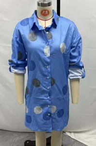 Detailed view of long-sleeved light blue shirt dress with polka dots on a mannequin