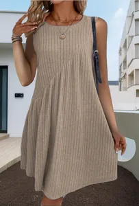 Dettaglio di un abito smanicato a coste kaki con orlo asimmetrico in stile boho.
